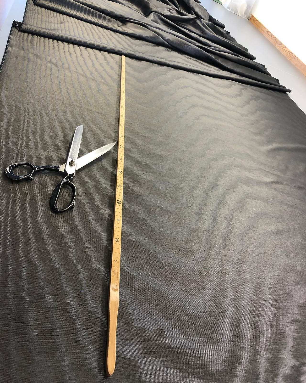 Dark curtain fabric with a metre rule and shears on the cutting table