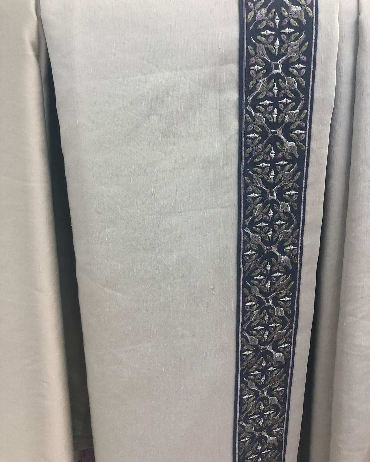 Linen curtain with an embroidered border band sewn on